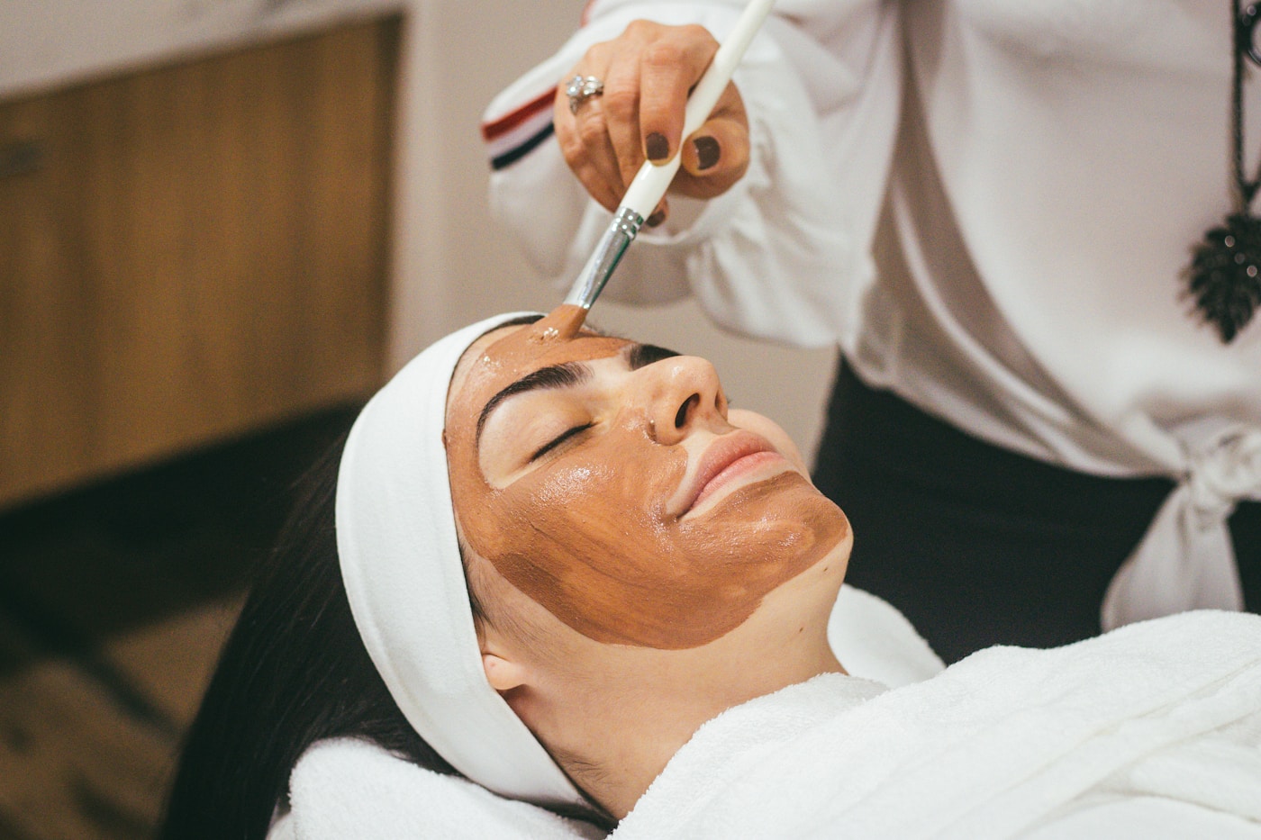Profissional realizando um cuidado facial em uma cliente
